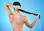 Shower, woman rinsing hair from back and blue background in morning bathroom routine, hygiene and studio mockup. Healthy haircare, wellness and fresh beauty model cleaning in water with mock up space