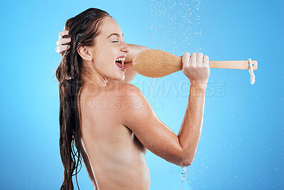 Buy stock photo Shower singing, skincare and woman with happiness karaoke in a studio. Bathroom, music and happy wet female model with isolated blue background and cleaning brush for beauty routine, wellness and fun