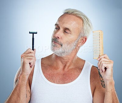 Buy stock photo Senior man, shaver and comb thinking for grooming, skincare or hair removal against studio background. thoughtful mature male holding razor blade and brush for haircare, cosmetics or facial treatment
