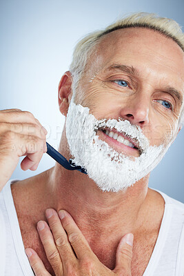 Buy stock photo Senior man, face and razor shaving beard with cream for grooming, skincare or hair removal against a studio background. Happy mature male with shaver, creme or foam for hygiene or facial treatment