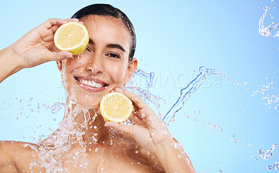 Buy stock photo Beauty, lemon and water splash with portrait of woman in studio for natural cosmetics, nutrition and detox. Glow, fruits and hydration with female on blue background for diet, clean face and skincare