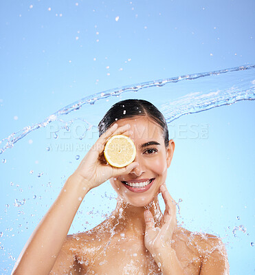 Buy stock photo Spa, lemon and water splash with portrait of woman in studio for natural cosmetics, nutrition and detox. Glow, fruits and hydration with female on blue background for diet, clean face and skincare