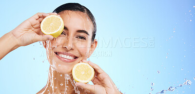 Buy stock photo Beauty, lemon and water splash with portrait of woman in studio for natural cosmetics, nutrition and mockup. Glow, fruits and hydration with female on blue background for vitamin c, face and skincare