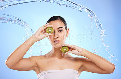 Buy stock photo Kiwi, portrait and water splash of woman, beauty and wellness on studio blue background. Female model, shower and healthy fruits for natural benefits, detox skincare and dermatology of diet nutrition