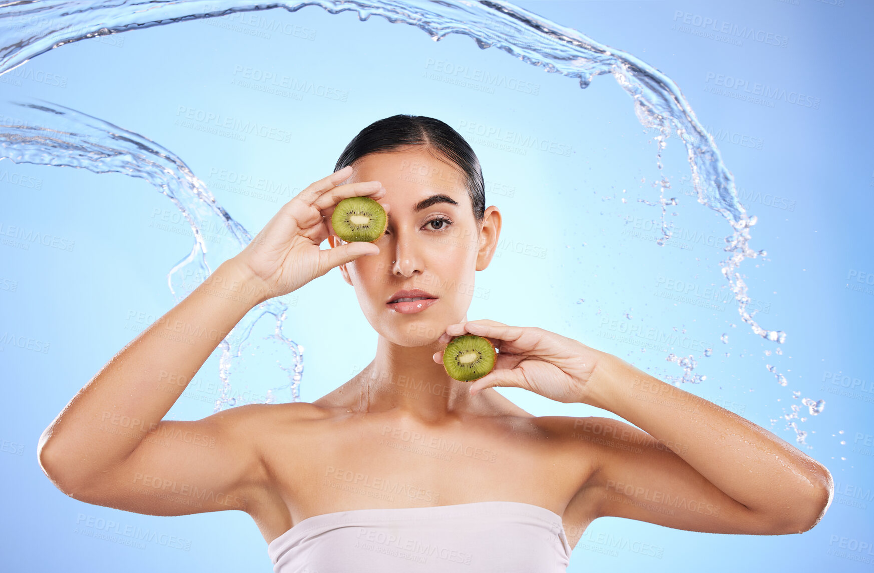 Buy stock photo Kiwi, portrait and water splash of woman, beauty and wellness on studio blue background. Female model, shower and healthy fruits for natural benefits, detox skincare and dermatology of diet nutrition