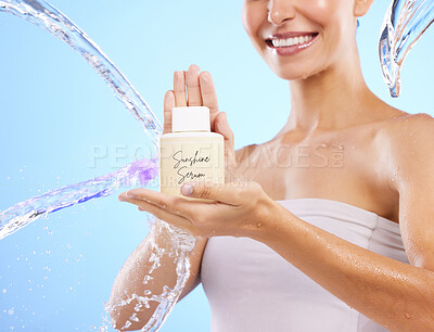 Buy stock photo Woman, hands and water splash for skincare serum, product or cream against a blue studio background. Hand of happy female smile holding moisturizer creme for beauty cosmetics or facial treatment