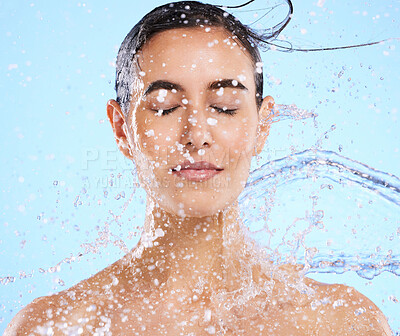 Buy stock photo Water, splash and skincare with a woman in studio on a blue background for beauty, hygiene or hydration. Relax, wellness and cleaning with an attractive young female in the shower for self care