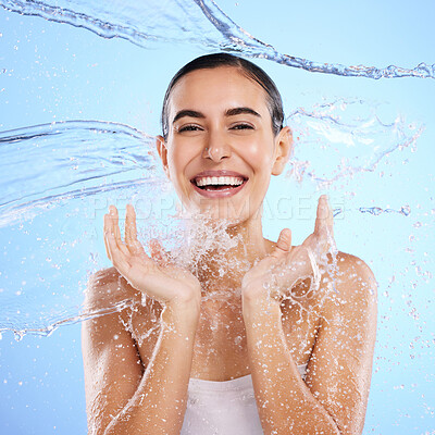 Buy stock photo Water splash, portrait and happy woman cleaning on blue background, studio and excited for wellness skincare. Female model, smile and shower for beauty, facial hydration and aqua on color backdrop 