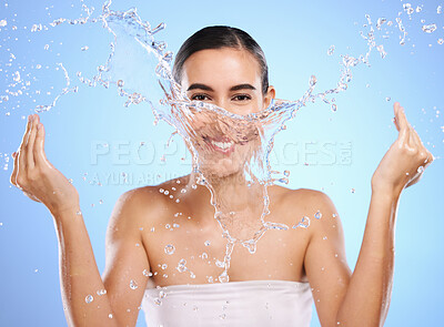 Buy stock photo Water splash, portrait or happy woman and face wash for skincare or hygiene on blue background in studio. Smile, wet or model and clean hands in wellness washing, beauty grooming or facial treatment 