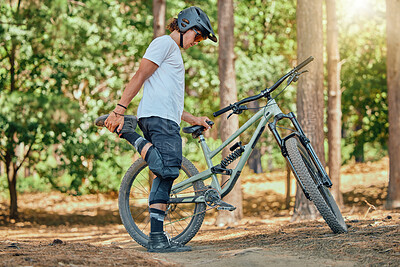 Buy stock photo Bike, fitness and man in forest, stretching and workout for balance, cardio and energy for wellness. Male biker, guy and athlete stretch legs, nature and outdoor for exercise, cycling and warm up