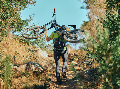 Back, man and carrying bicycle in nature, walking and traveling outdoor in woods. Sports, fitness and male cyclist or athlete carry mountain bike for exercise, training or workout for transportation.