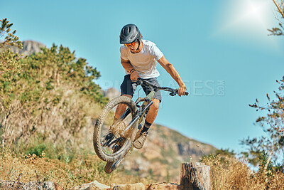 Buy stock photo Cycling, jumping and man on bicycle in the countryside for fitness, stunt and freedom on blue sky background. Nature, biking and guy cyclist training, practice and speed, action and free in Mexico