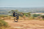 Extreme sports, bicycle and man cycling in the countryside for fitness, stunt and freedom. Nature, biking and sporty male cyclist training, practice and speed, action and free on Mexico dirt road