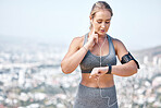 Fitness, woman and smart watch checking heart rate, pulse or tracking running performance with earphones in nature. Active and fit female runner listening to music and monitoring healthy wellness