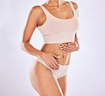 Body, underwear and stomach of a woman or natural model with smooth skin isolated in a studio white background. Weight loss, diet and female touch belly for healthcare, fitness and nutrition