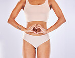 Woman, heart and hands on stomach in studio as motivation for weight loss, diet or fitness. Female on a white background with hand emoji or shape for gut health, wellness or skin care in underwear