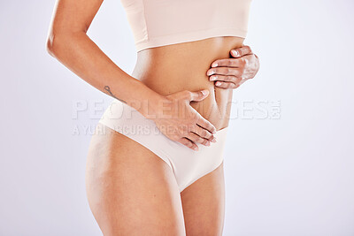 Buy stock photo Woman, hand on stomach and body for healthy lifestyle in studio as motivation for weight loss, diet or fitness. Female on a white background  for gut health, wellness or skin care in underwear