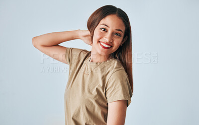 Buy stock photo Portrait, smile and a woman in studio on a gray background feeling positive, carefree or cheerful. Face, happy and freedom with an attractive young female posing in clothes for contemporary fashion