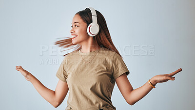 Buy stock photo Woman, music headphones and dancing in studio while happy, excited and positive. Female model on white background to dance with hands, fun and smile with energy and listening to audio or radio