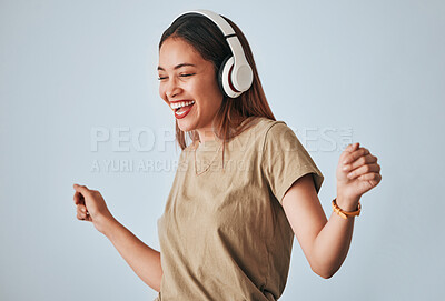 Buy stock photo Happy woman, music headphones and dancing in studio with excited and positive mindset. Female model on white background to dance, fun and laughing with energy while listening to audio or radio
