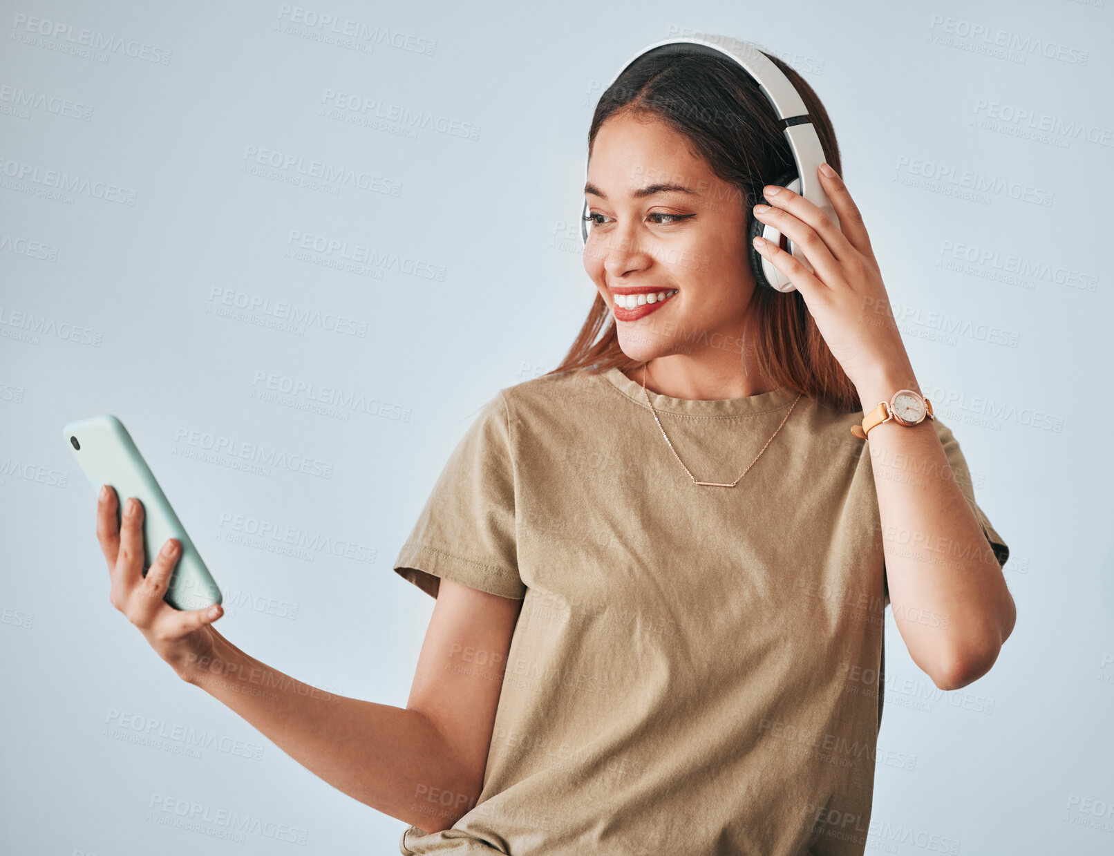 Buy stock photo Woman, music headphones and phone in studio while happy, excited and positive. Female model on white background with smartphone for internet connection or subscription listening to audio or radio