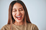 Woman is laughing, happiness and face with freedom isolated on studio background, comedy and care free. Headshot, young female and joy with laughter, funny and mockup with humor and positive energy