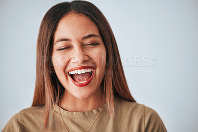 Buy stock photo Woman is laughing, happiness and face with freedom isolated on studio background, comedy and care free. Headshot, young female and joy with laughter, funny and mockup with humor and positive energy