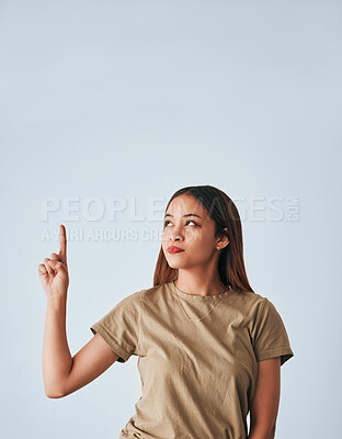 Buy stock photo Idea, thinking and a pointing woman with space isolated on a white background in a studio. Direction, mockup and a girl gesturing for a plan, contemplation or a decision on a backdrop or wall
