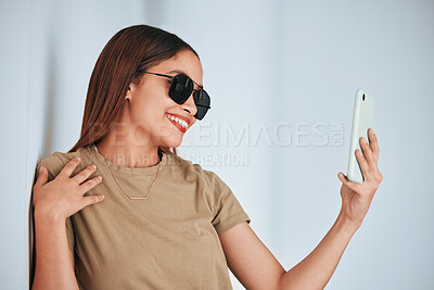 Buy stock photo Woman, wall and sunglasses in selfie with cellphone, smile and excited with fashion for summer. Girl, student and influencer with social media app, photography and profile picture with happiness