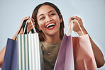 Portrait, happy woman and shopping bag isolated on studio background wealth, financial freedom or sales promotion. Retail, fashion and beauty face of biracial person or customer with paper bags offer