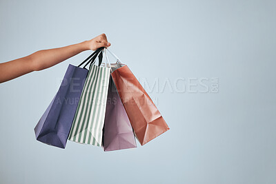 Buy stock photo Hands, shopping bags and purchase on studio mockup for fashion, discount or sale against a gray background. Hand of shopper holding bag of gifts, present or luxury retail products on copy space