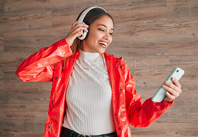 Buy stock photo Headphones, phone and happy woman with music isolated on wood background, audio streaming and mobile app. Gen z student or biracial person with cellphone, electronics sound or online audio technology