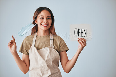 Buy stock photo Coffee shop, covid and a woman holding an open sign in studio on a gray background after lockdown. Portrait, small business startup and cafe with a female entrepreneur indoor to display advertising