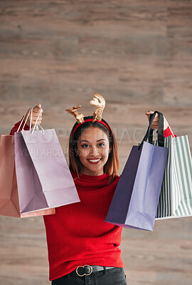 Buy stock photo Shopping bags, happy and female with a christmas headband for a festive or holiday celebration. Happiness, smile and portrait of a woman model with gifts or presents with xmas reindeer ears for event