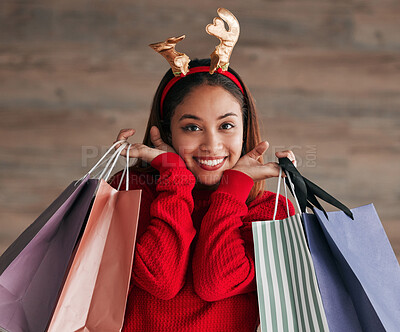 Buy stock photo Bags, portrait and woman with a reindeer headband for a festive, xmas holiday celebration. Happy, smile and face of a female model shopping for gifts or presents with christmas accessories for event.