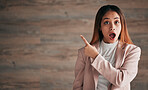Shocked woman, portrait and pointing on mockup for announcement, advertising or marketing. Surprised business female point finger to copy space in shock for advertisement against a studio background