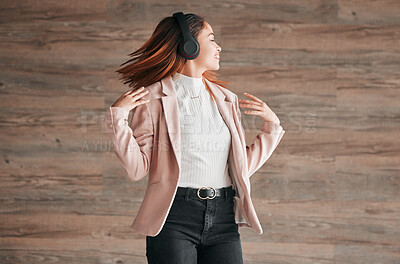 Buy stock photo Dancing, happy and woman listening to music with happiness or streaming audio online using headphones. Radio, wellness and excited female person dance isolated in a wooden wall background