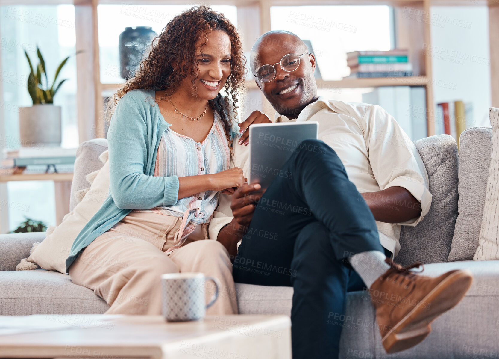 Buy stock photo Mature couple, tablet and sofa with smile in living room for bond, love and video on app for memory. Black man, woman and mobile touchscreen to watch movie on web, house and lounge couch to relax