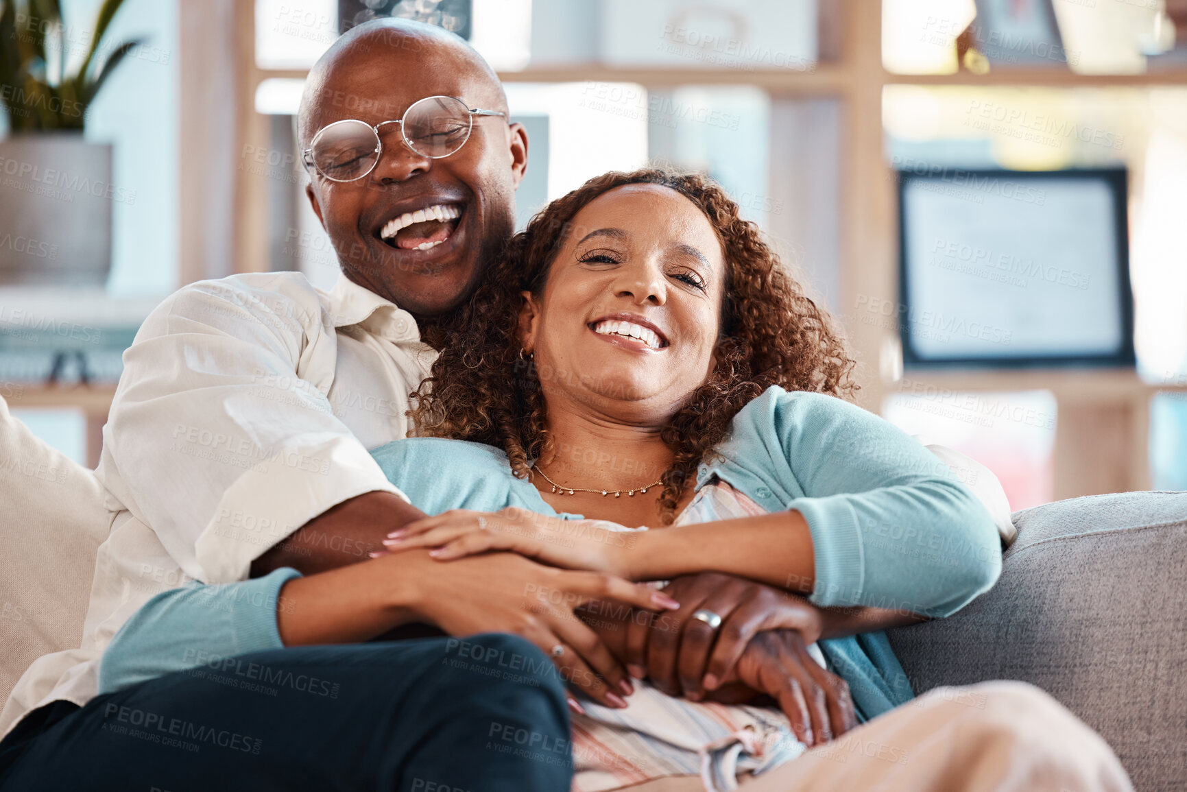 Buy stock photo Couple, hug and laughing on sofa portrait in home living room, bonding and having fun. Interracial, love and funny black man and mature woman on couch embrace, relax and enjoying comedy together.