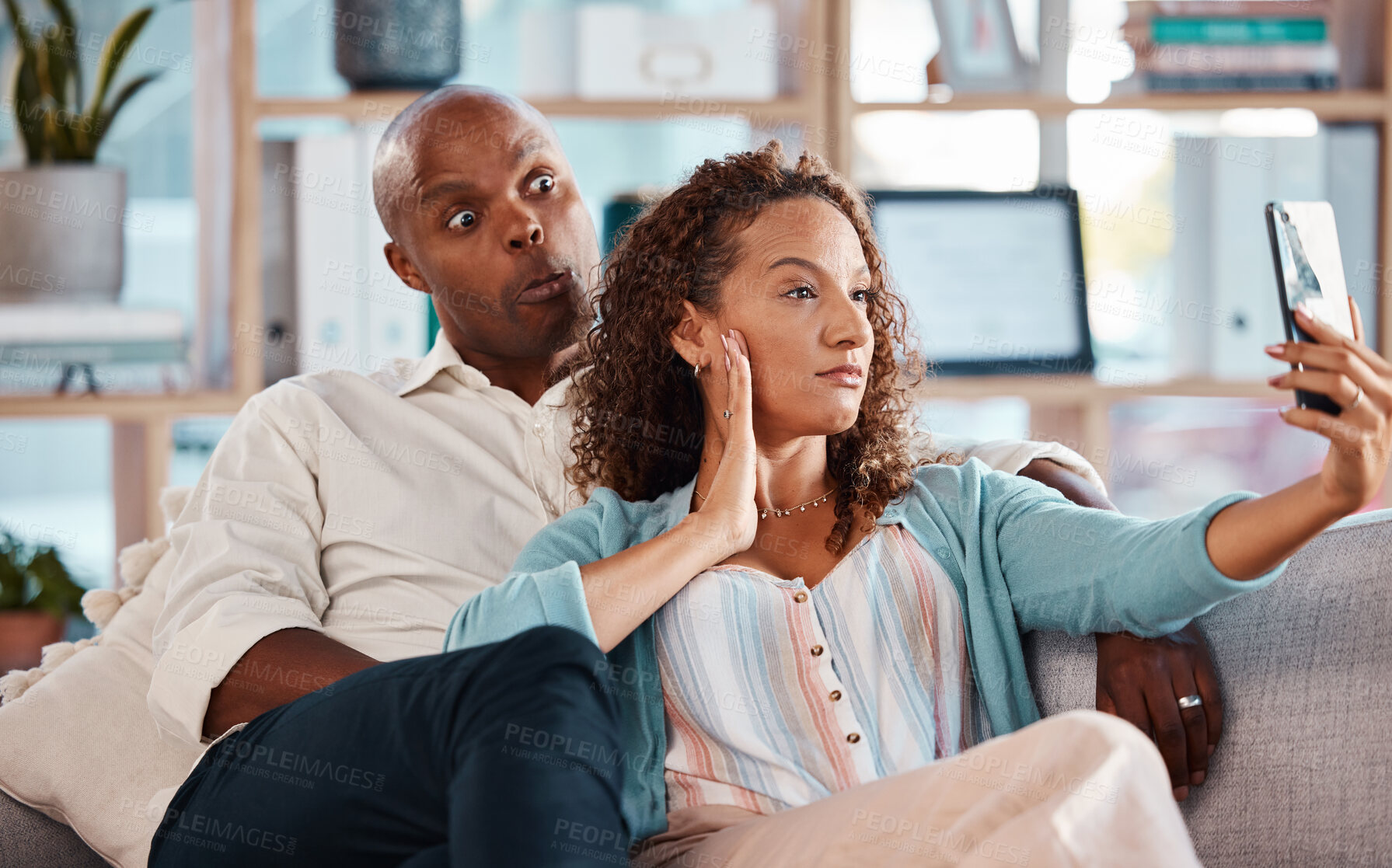 Buy stock photo Couple, selfie and funny face on sofa in home living room, bonding or having fun. Interracial, self picture and black man and mature woman relax while taking photo for memory or social media together