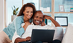 Laptop, relax and a couple watching a video on a sofa in the living room of their home together for entertainment. Computer, movie or streaming with a man and woman enjoying a series while bonding