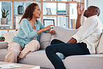 Couple, fight and argue on sofa for marriage problems, breakup or bad communication in lounge. Divorce, crisis and frustrated people in conflict, angry partner and betrayal of cheating, drama or hate