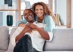 Couple, hug and laughing on sofa portrait in home living room, bonding and having fun. Interracial, love and funny black man and woman on couch embrace, happiness and enjoying quality time together.