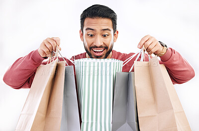 Buy stock photo Wow, sale and happy man with shopping bag in studio, excited for discount or purchase on white background. Deal, excited and indian guy with product form shop, mall or market while posing isolated