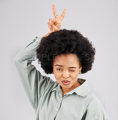 Buy stock photo Goofy, happy woman and portrait with a wink, pout and bunny ears hand sign in a studio. Isolated, grey background and peace emoji hands of a female model feeling funny with fun comedy and joke