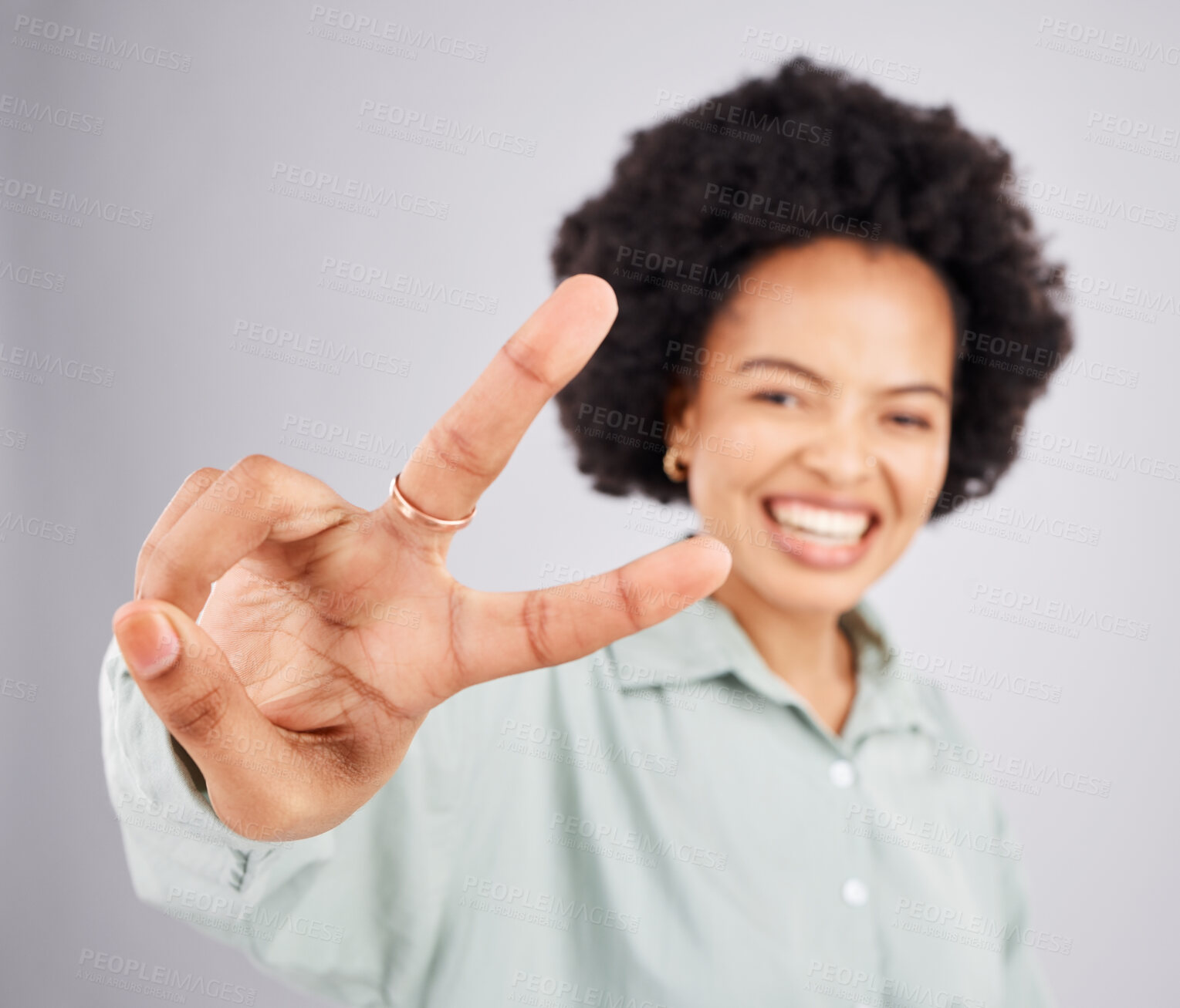 Buy stock photo Portrait, peace and hand gesture with a woman in studio on a gray background feeling happy or carefree. Smile, emoji and sign with a happy young female indoor for freedom, wellness or good vibes