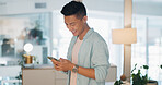 Cellphone, networking and Asian man on social media in the office typing on a lunch break. Technology, happy and male employee with a smile browsing internet or mobile app with cellphone in workplace