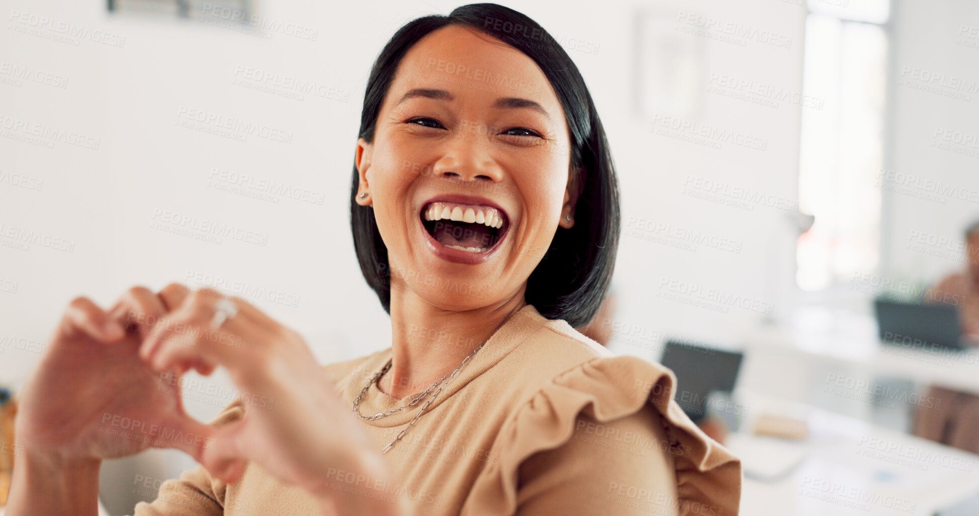 Buy stock photo Asian woman, smile and heart sign in the office for happy, excited or love emoji  hand sign. Employee, female professional and excited laughing in a creative agency with web designer and support