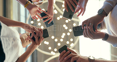 Buy stock photo Business people, phone and hands in team networking, communication or social media together below. Low angle of employee group typing in circle for online data sync or app share on mobile smartphone