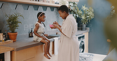 Mother, child and breakfast with mom feeding girl food for nutrition, growth health and wellness in home kitchen. Black woman with girl at family house for quality time, love and eating healthy